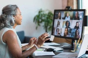 A businessperson leads a team meeting using video chat.
