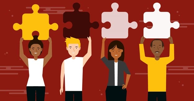 A diverse group of people holds connecting puzzle pieces over their heads.