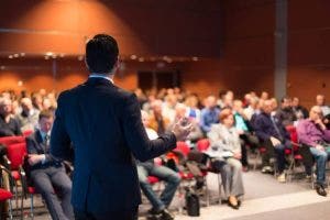 A communications manager gives a presentation to a crowded hall.